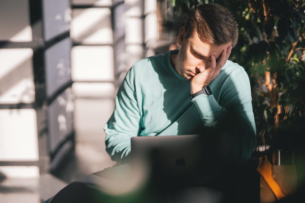 Anxious job seeker looking into computer screen
